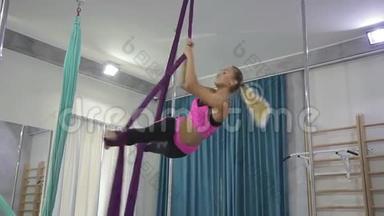 健身妇女在<strong>室内</strong>运动俱乐部做伸展腿<strong>吊床</strong>。